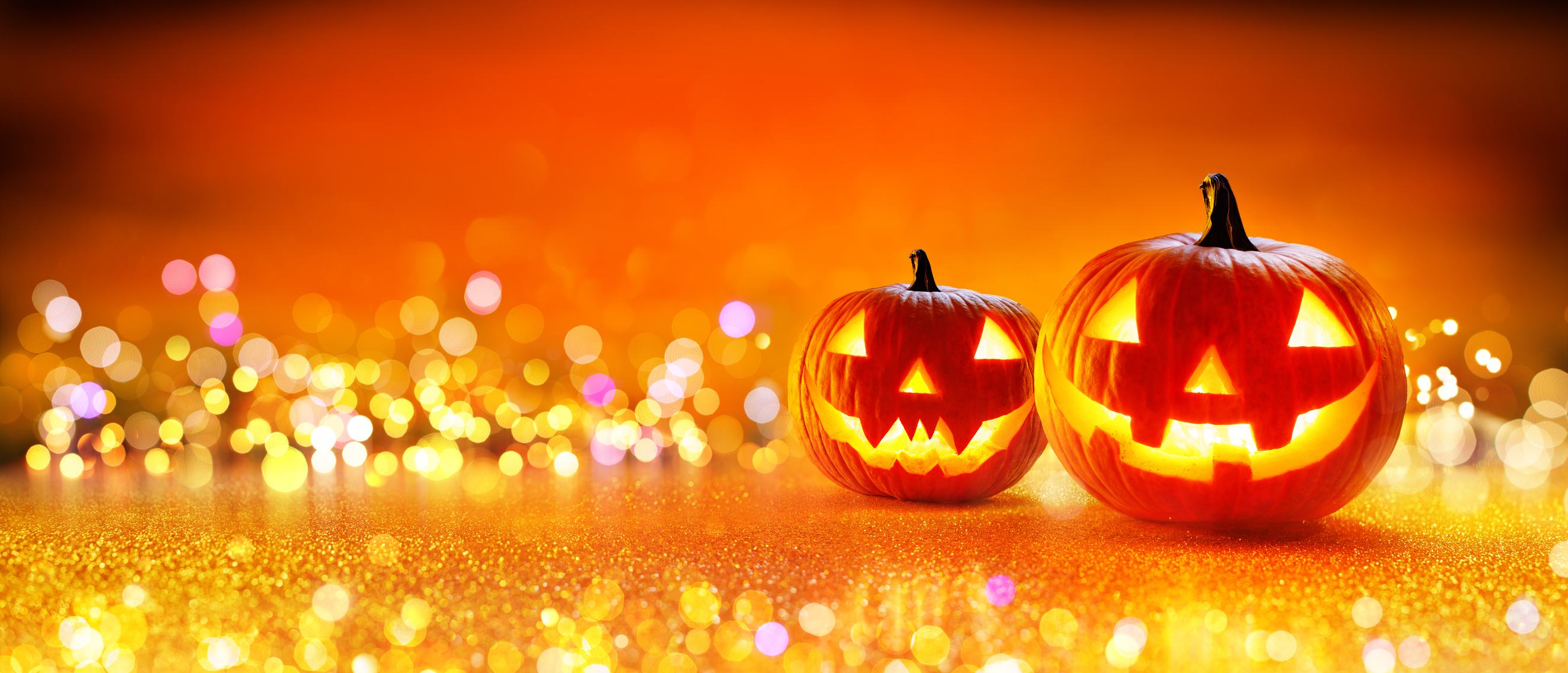 Carved Pumpkin With Golden Glitter and Bokeh Background